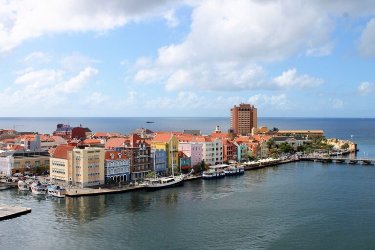 Vue aérienne du port de Curaçao avec des maisons colorées et des bateaux.