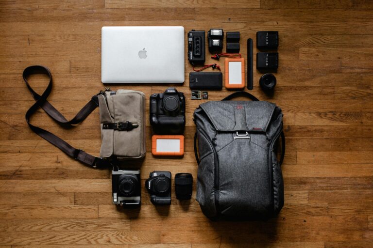 Outils technologiques tels que des caméras et un ordinateur installés sur le sol près de deux sacs.